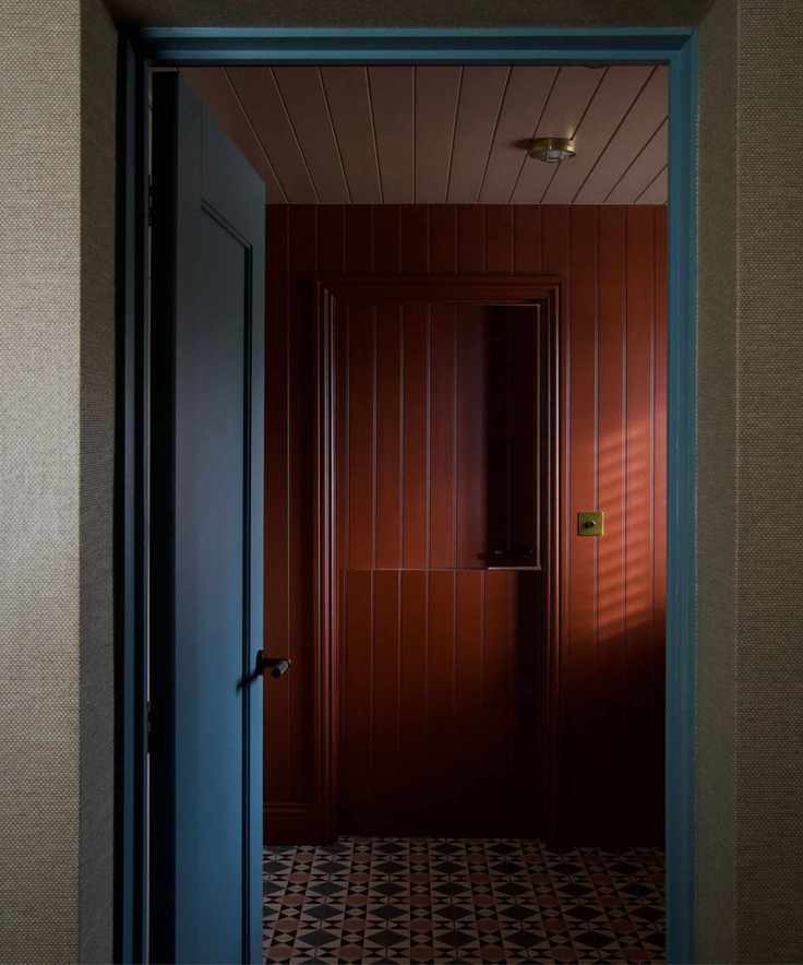 dark red room with paneling with blue woodwork accents in hallway by alice grace interiors