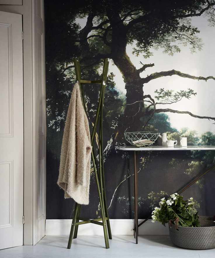Striking bedroom accent wall with a painted green and white forest mural, complemented by a sleek metal console table.