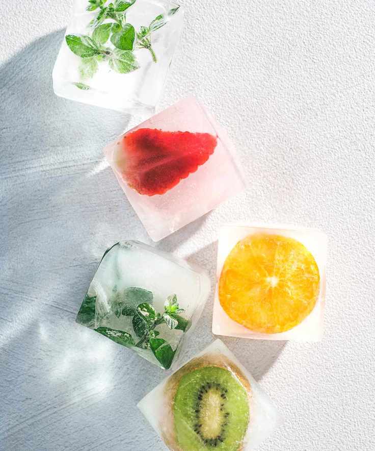 Colorful ice cubes with fruit and herbs