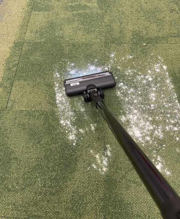 Tineco Pure One Station vacuuming flour and sugar on green carpet
