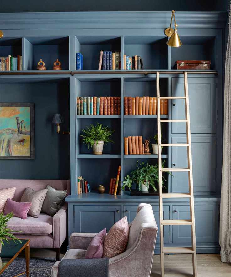 Bespoke blue cabinetry, wooden ladder, decorated with books, plants and ornaments