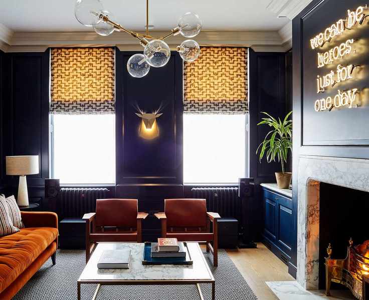 Glass pendant lighting, a wall light and a table lamp against dark purple walls as examples of small living room lighting ideas.