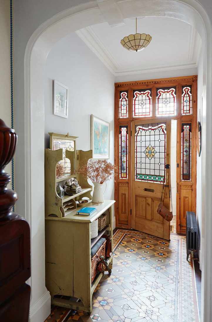 Hallway with storage unit and front door with stained glass