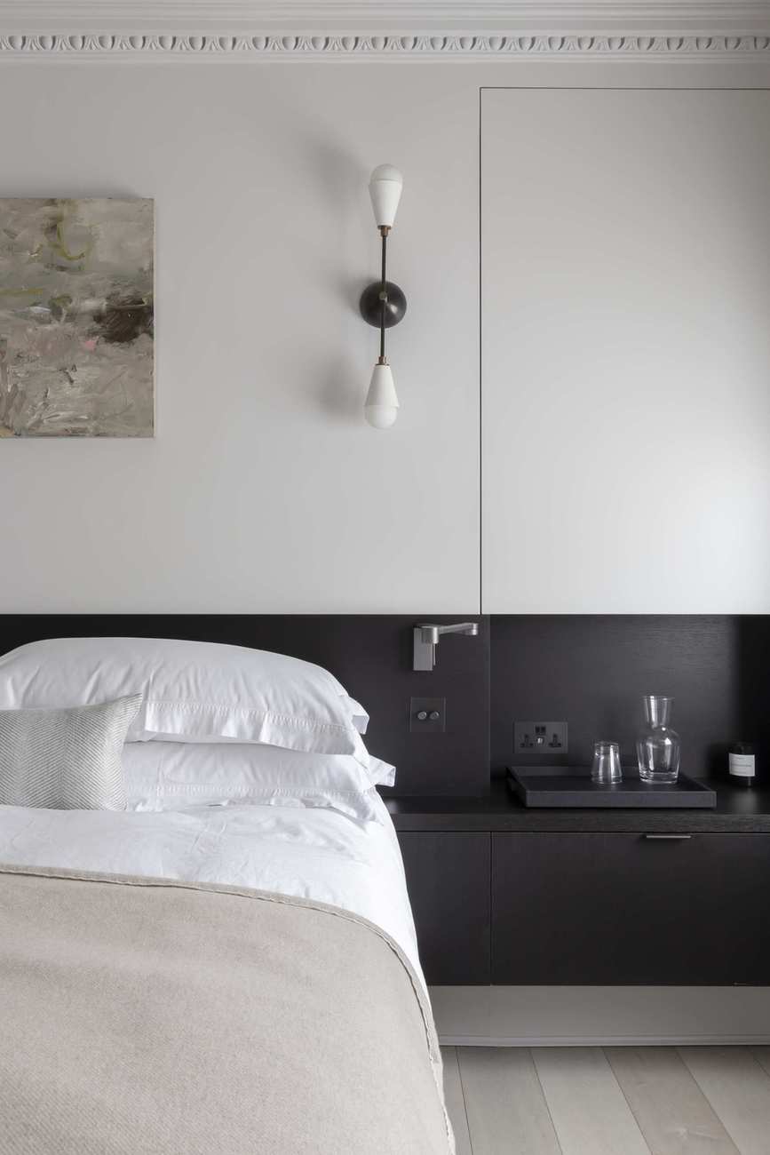 Black and white bedroom with built in storage, wall leith, wooden floor, artwork