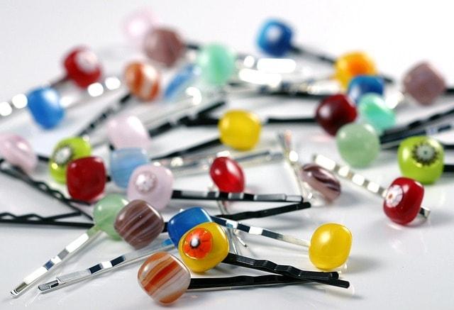 Bobby pins on display, showcasing their sleek metal design which has been a popular hair grip for women since their invention. They originated in the early 20th century, designed to hold bobbed hairstyles, influencing fashion trends over the years.