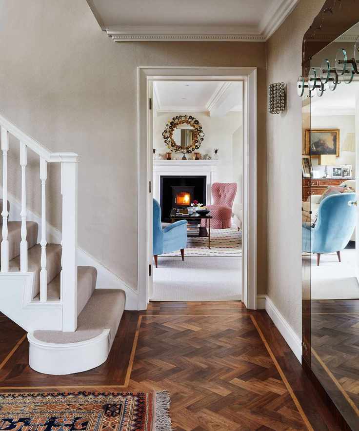 Neutral hallway with a carpeted staircase and dark wood flooring
