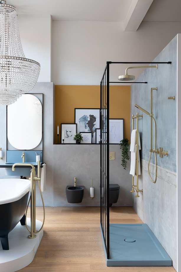 Shower design for a compact bathroom showcasing a glass screen and elegant chandelier.