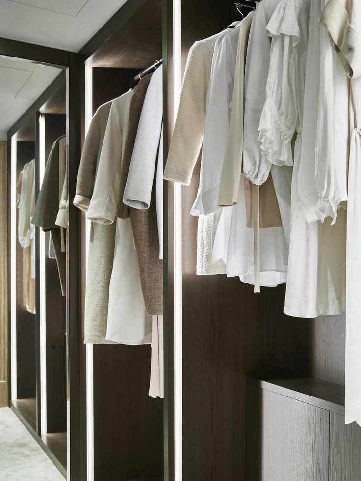 clothes hanging in a closet, illuminated