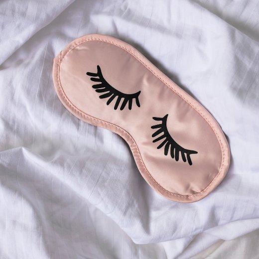 guide-to-under-eye-circles-blog-2.png Sleep mask on bed sheets promoting proper sleep to help with dark circles under the eyes