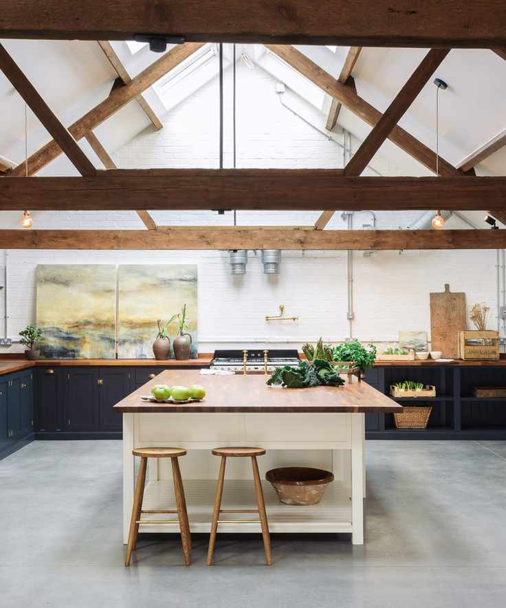 A country-style kitchen with statement lighting ideas and a brown wooden island.