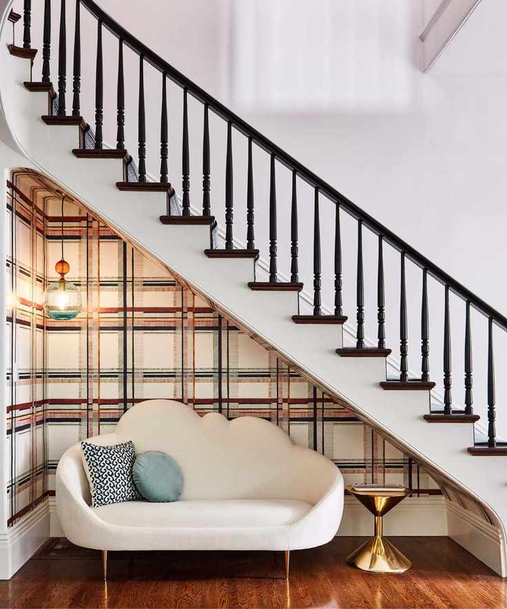 Sofa under the stairs with striped wallpaper