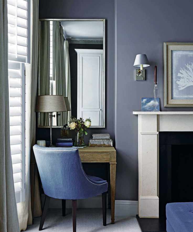 Blue bedroom showcasing a stylish mirror and cozy decor
