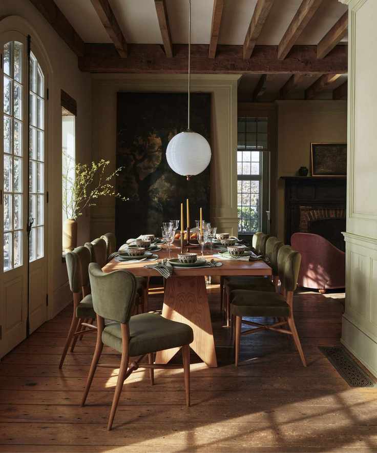 retro eclectic earthy dining room with a tapestry on the wall and green velvet upholstered dining chairs