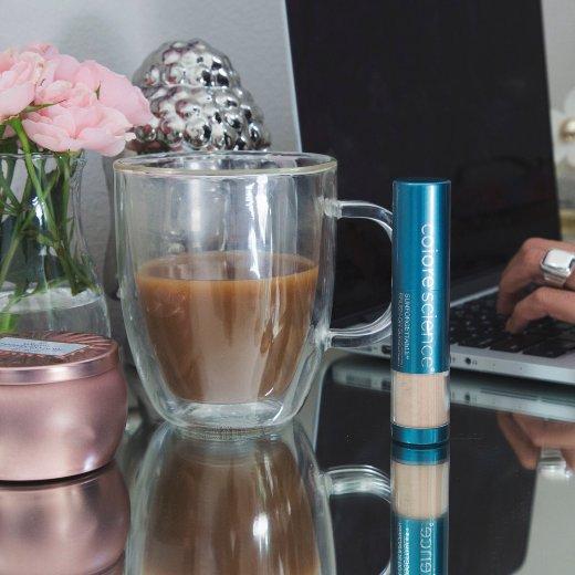 Image of Brush-On Shield SPF 50 on desk next to coffee