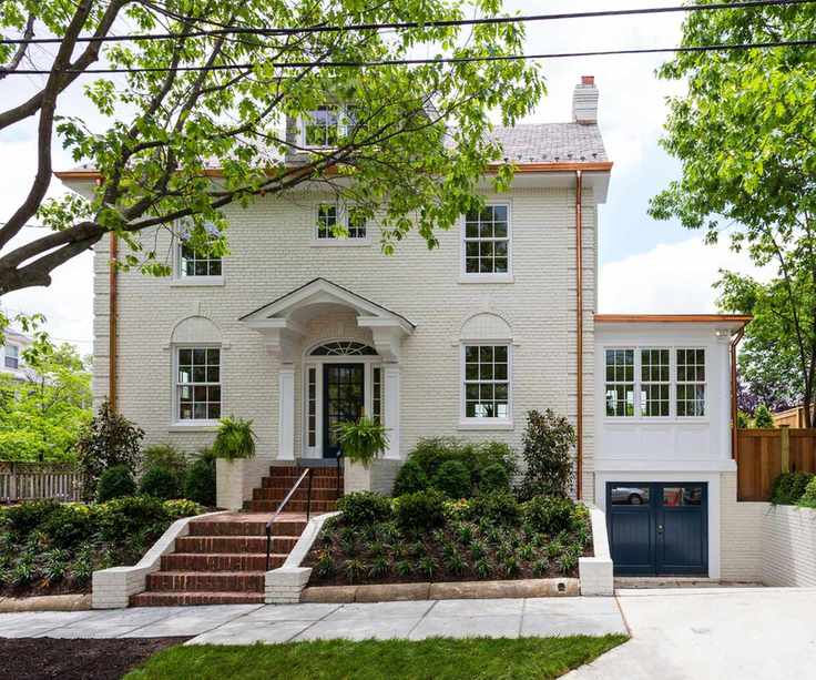 house exterior with cream painted brick with trees around