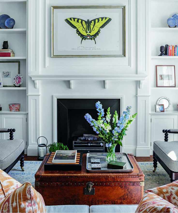 A butterfly artwork above a fire place in a white living room