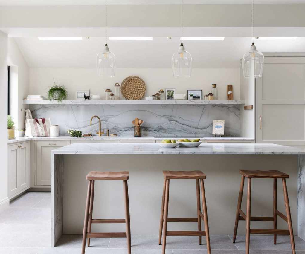 A kitchen featuring white cabinetry, marble surfaces, and open shelving