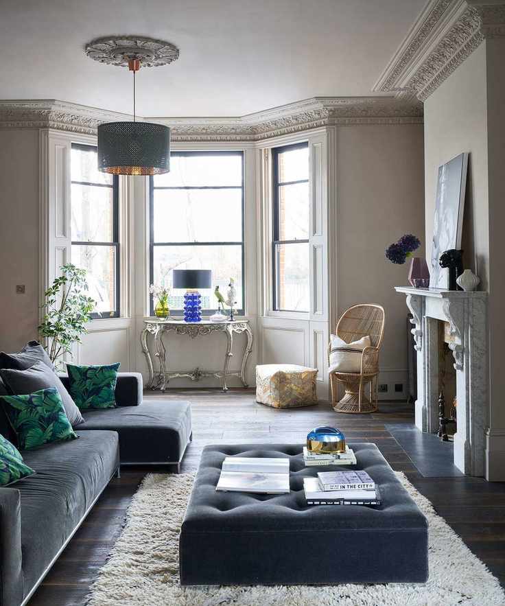 Beige living room with bold blue and teal furnishings and ornate architectural details.