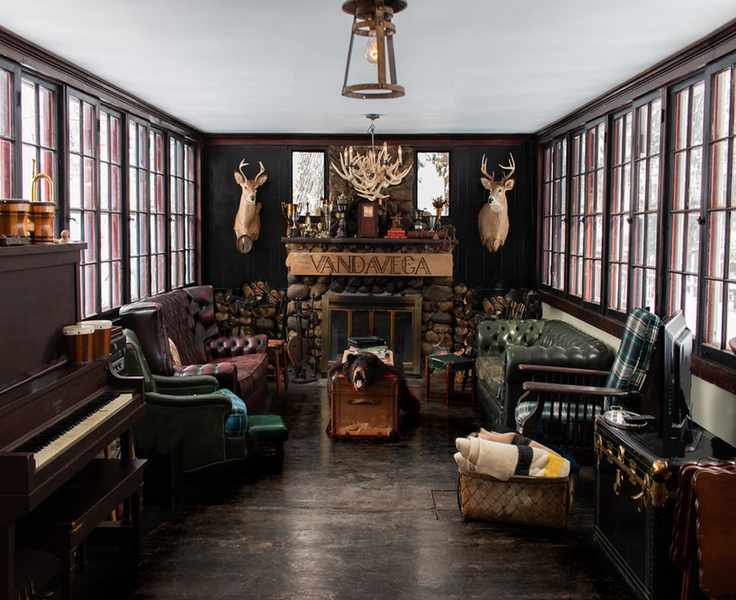 large cabin living room with dark walls and fireplace