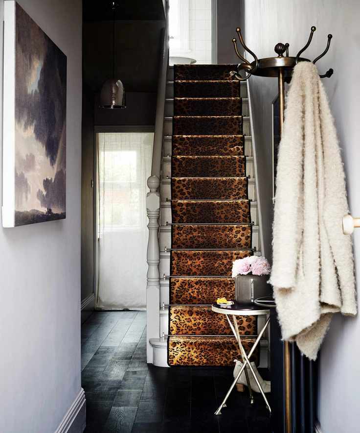Small hallway featuring a leopard print carpet, black flooring, and light lilac walls.