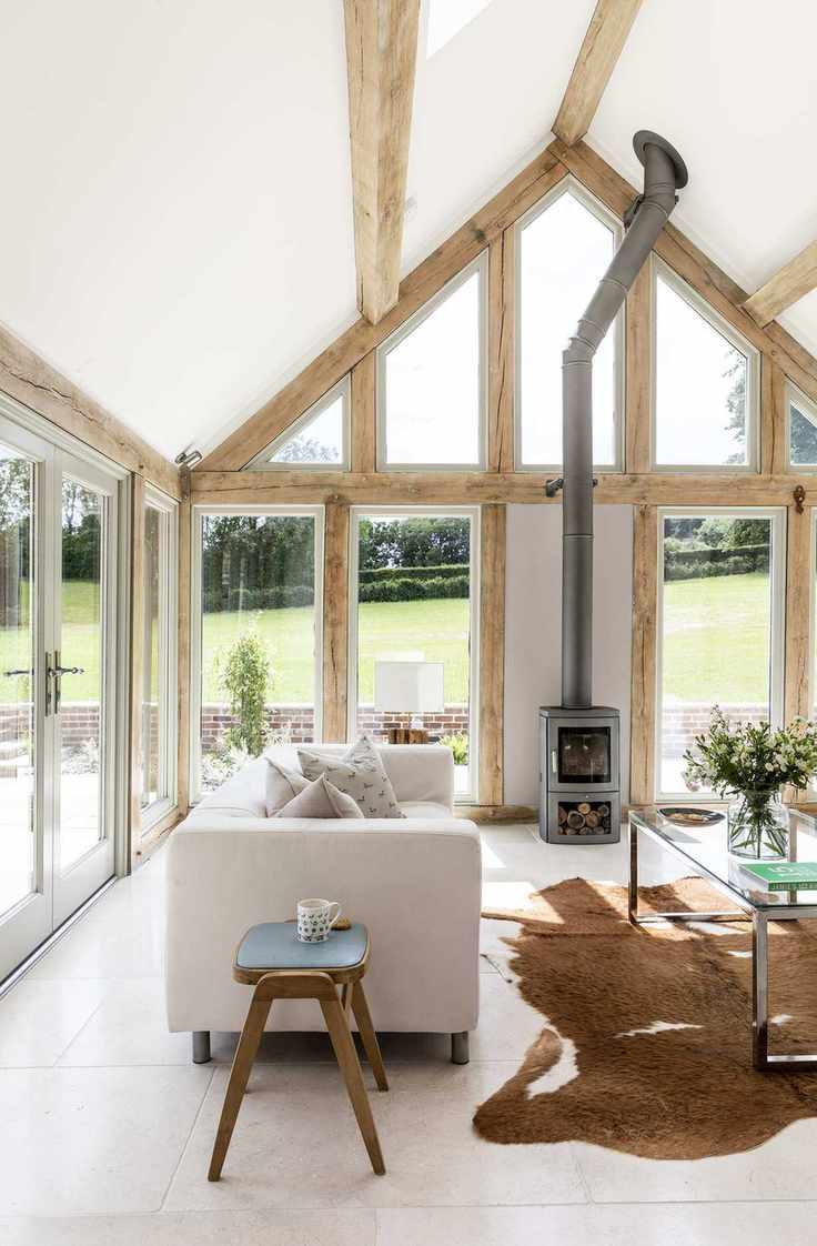 cozy sunroom with stoves and rug with soft cream sofa