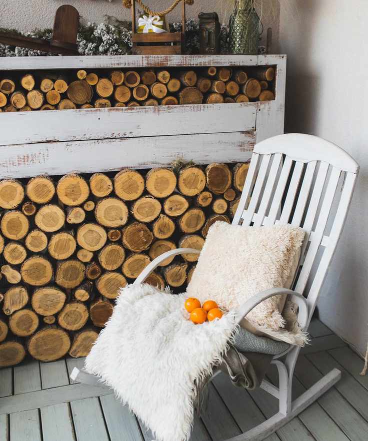 Log store and rocking chair set up on a balcony