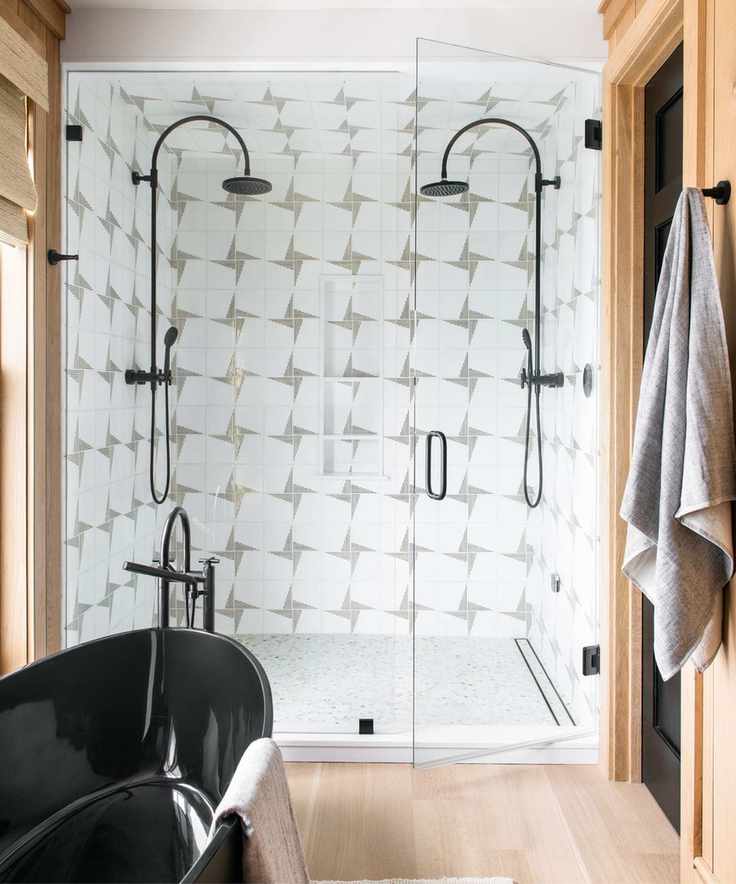 White and grey tiles, black shower heads and bath