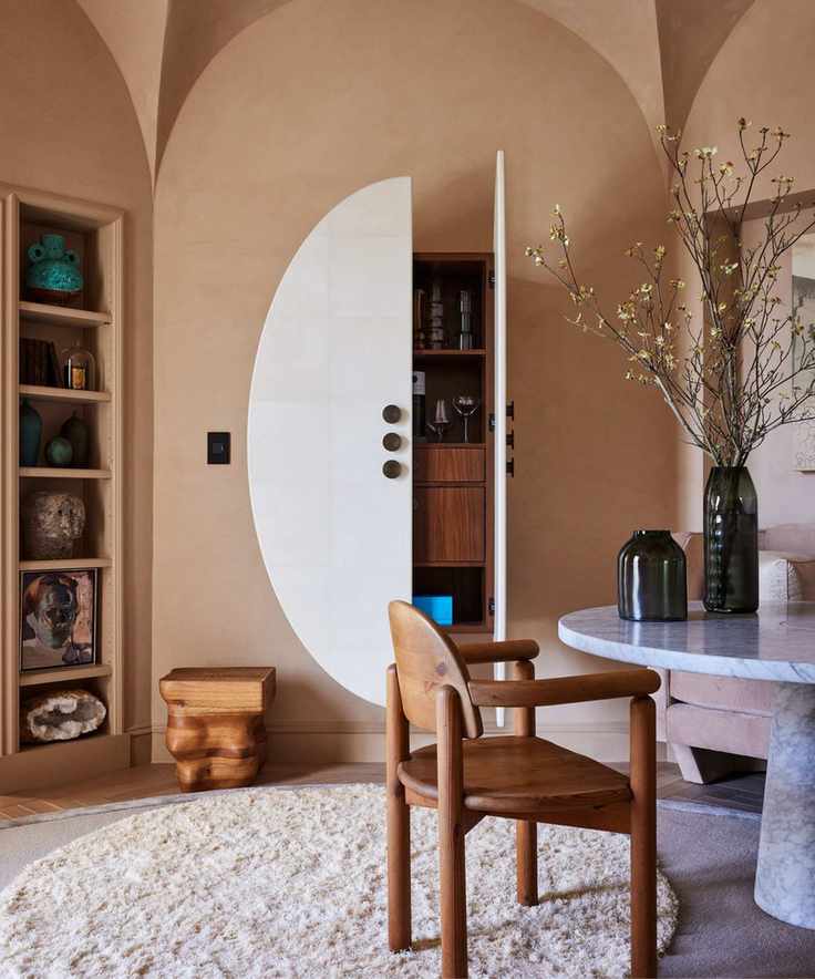 A dining room with Adobe Dust walls, featuring a marble table and decorative items.