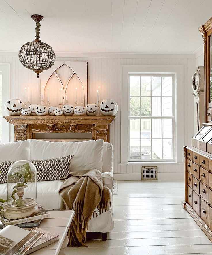 White living room with pumpkins on mantel