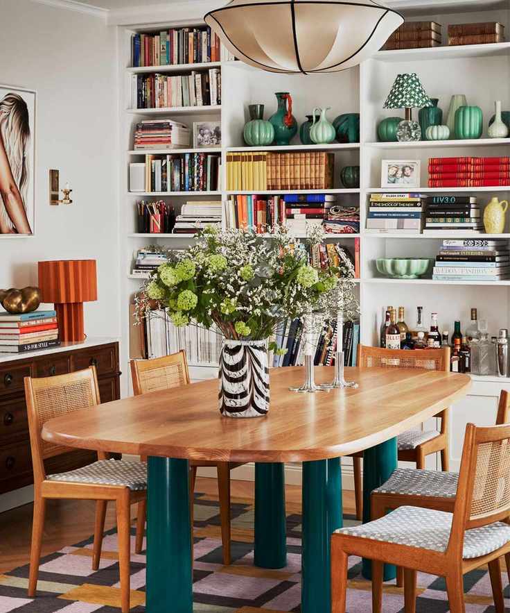 A maximalist dining room with a wall of bookshelves