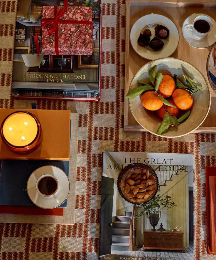 Ottoman from above decorated with a bowl of oranges and lit three-wick candle