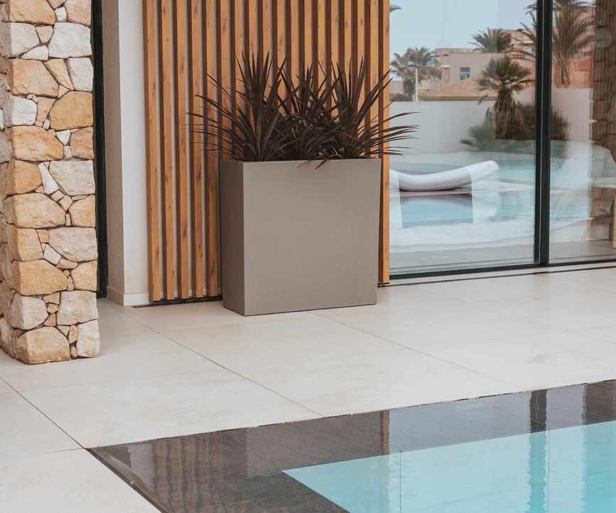 Junco planter with succulents near a pool