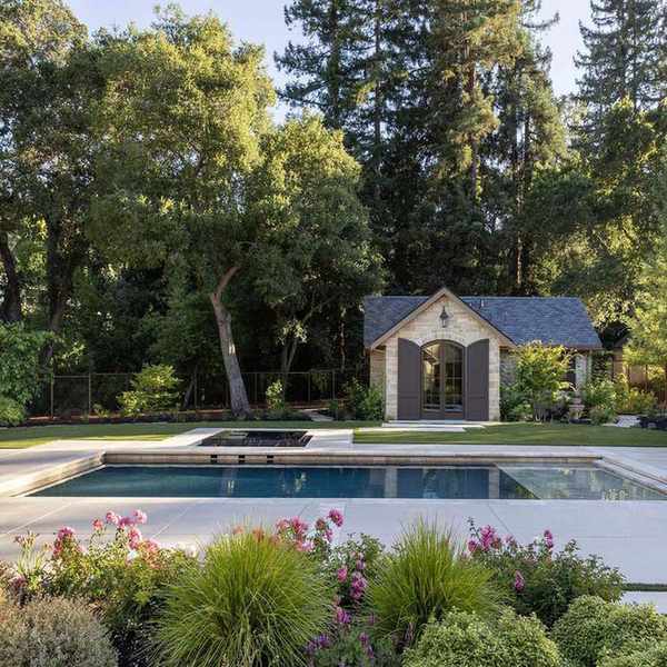 Modern, elegant backyard pool with ivory porcelain patio tiles