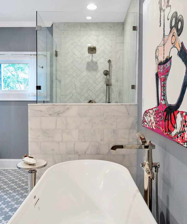 Gray bathroom with tiled shower, freestanding tub and large graphic art on the wall
