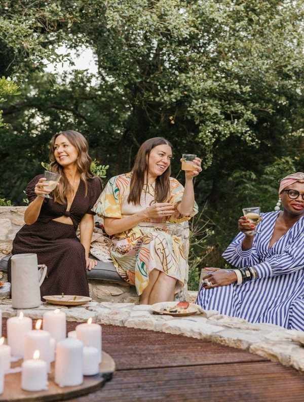 Women friends drinking wine outside.