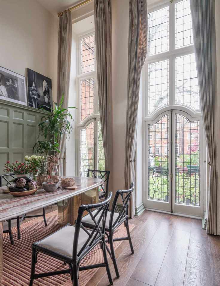 Residential Kensington dining room area designed by Erik Munro that features tall curtain panels and a marble dining table