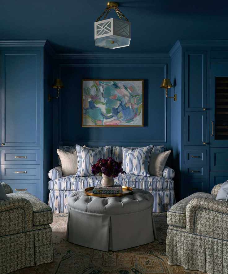 A living room with deep blue walls and coordinating cushions.