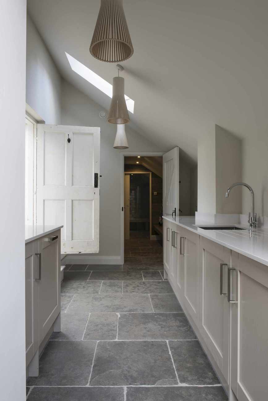 Narrow utility room with a sloped ceiling and feature lighting