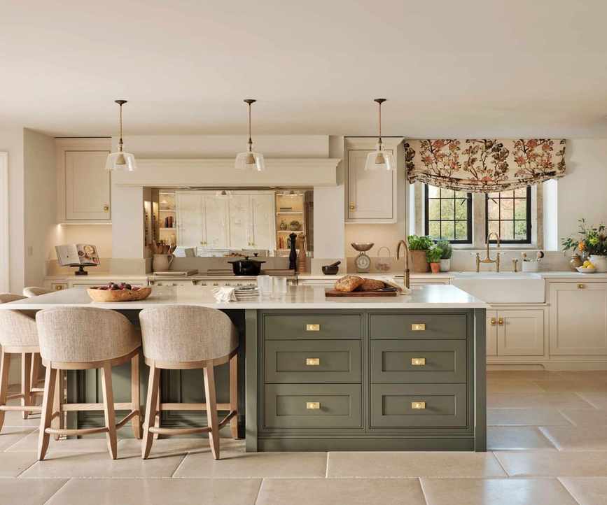 A midimalist kitchen featuring white cabinets and a green island