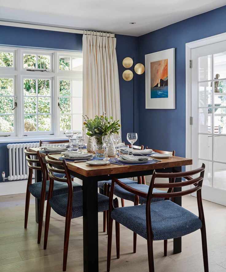 Dining room with blue walls and matching furniture accents