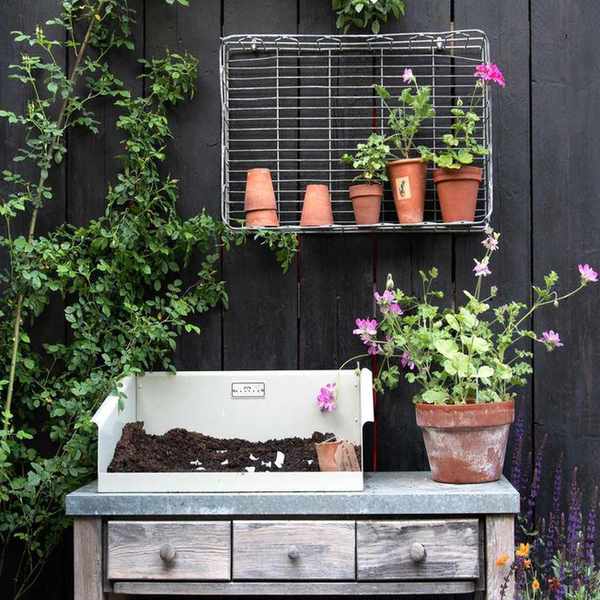 vintage potting table with soil and plants in terracotta pots