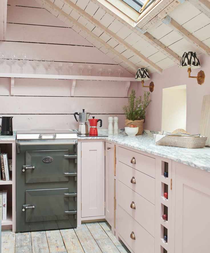 small pink rustic kitchen with a dark grey cooker