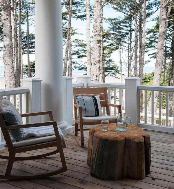 An example of roof garden ideas in a wooded area with rocking chairs, rustic coffee table and white picket fencing.
