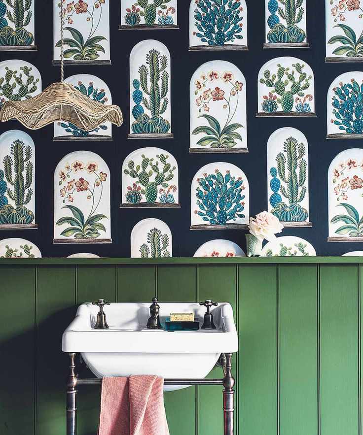 Cloakroom with wood paneling painted green, featuring a basin and botanical wallpaper
