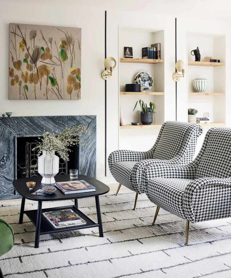Living room with open layout with marble fireplace and black and white chairs