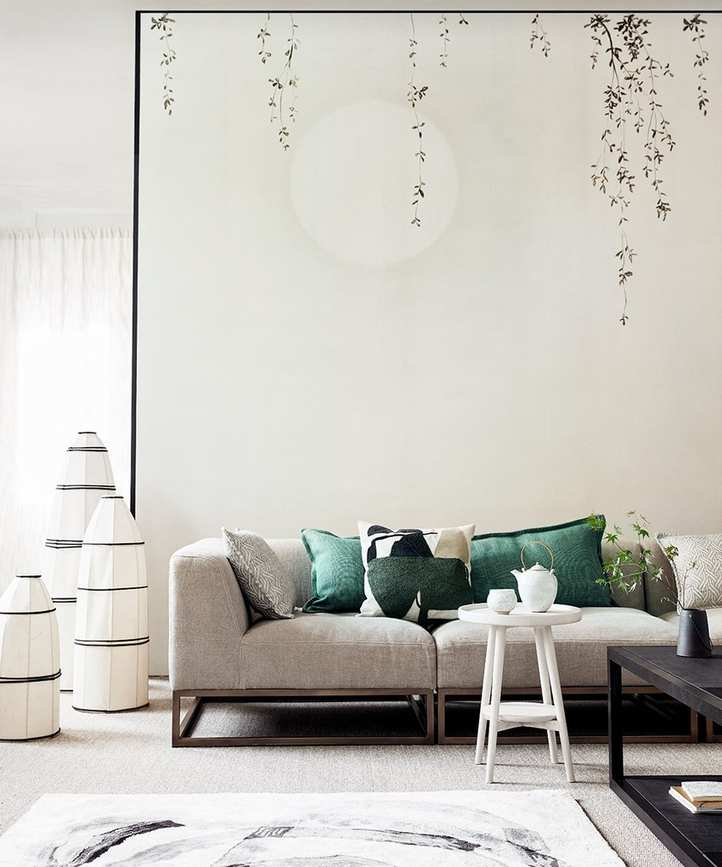 Japanese style living room picture with neutral walls and sofa and green cushions.