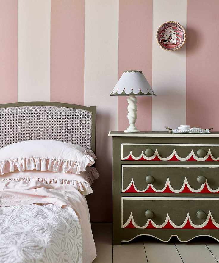 Vibrant bedroom featuring pink striped walls and chic decor