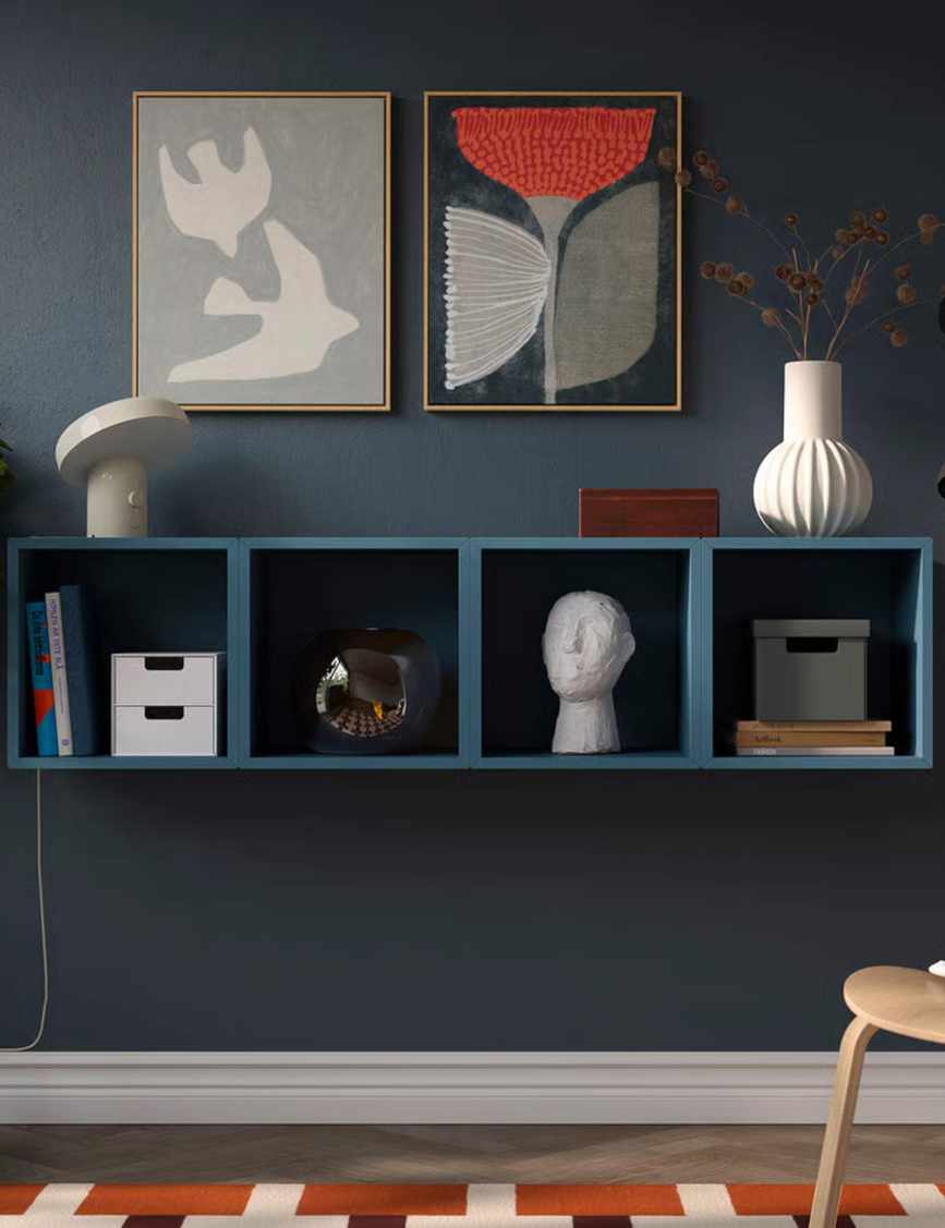 Blue wall-mounted shelf in a navy room with a geometric rug