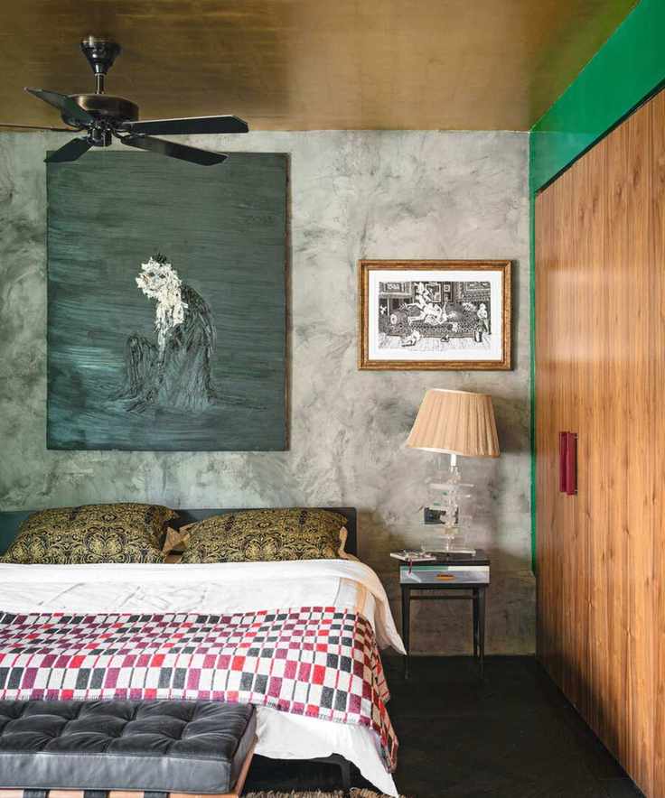 An eclectic bedroom featuring a gold foil ceiling and a ceiling fan.