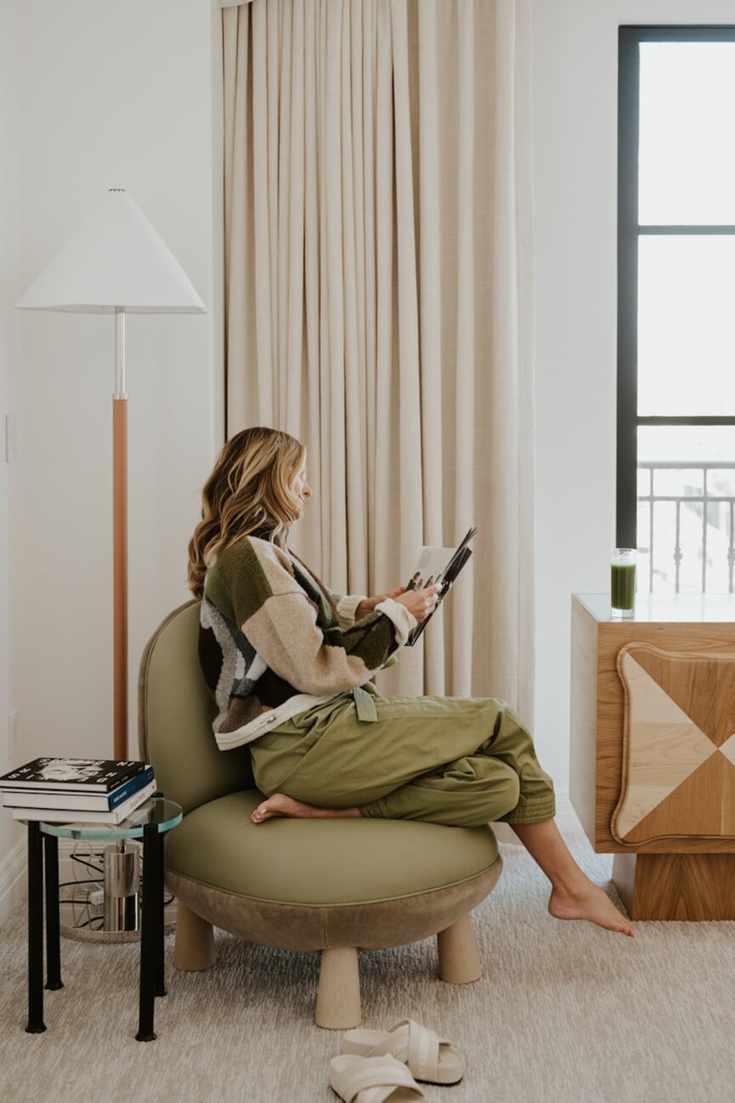 woman reading magazine in chair